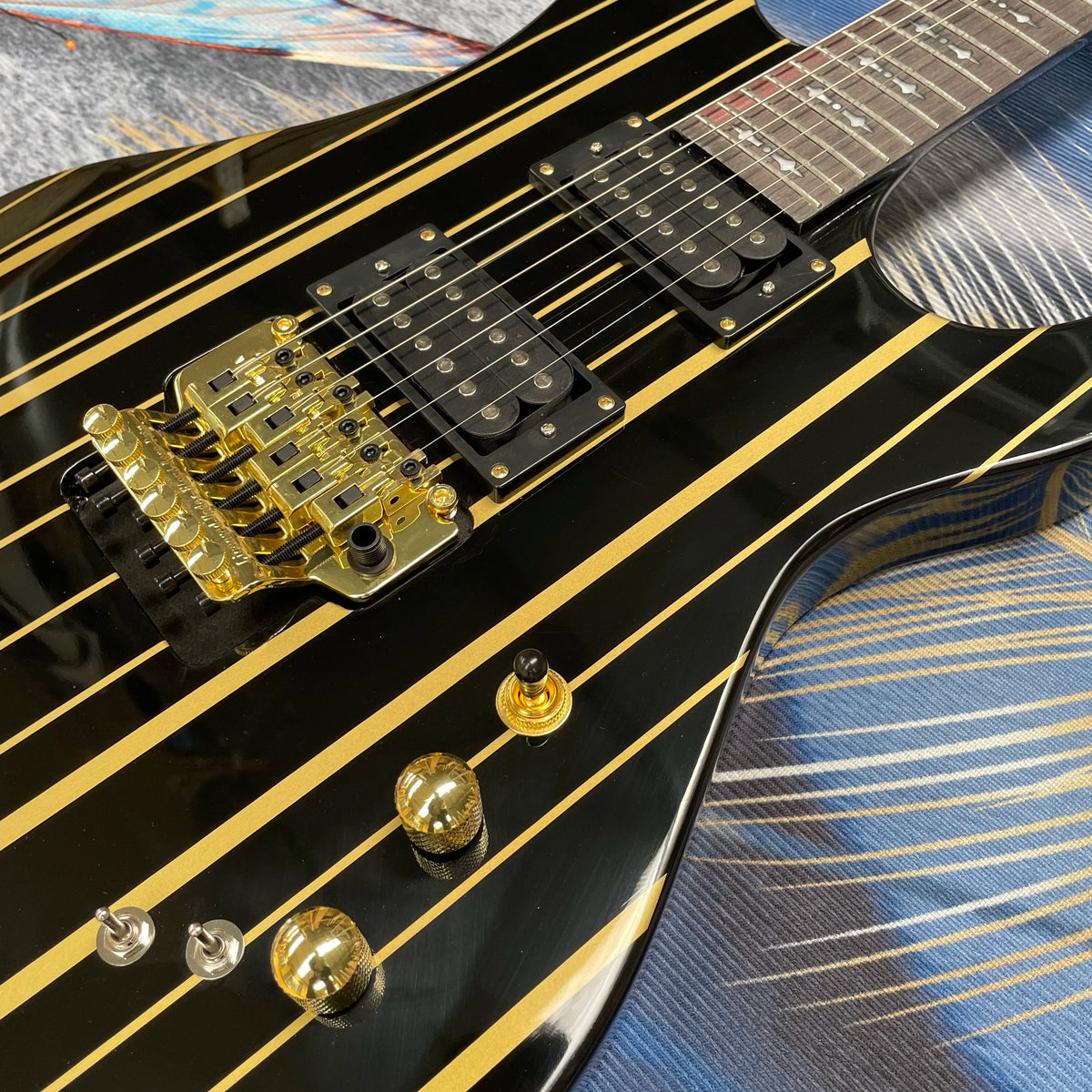 Guitarra eléctrica de 6 cuerdas con rayas negras y doradas, cuerpo de caoba con sonido rico, guitarra de heavy metal con doble bloqueo.
