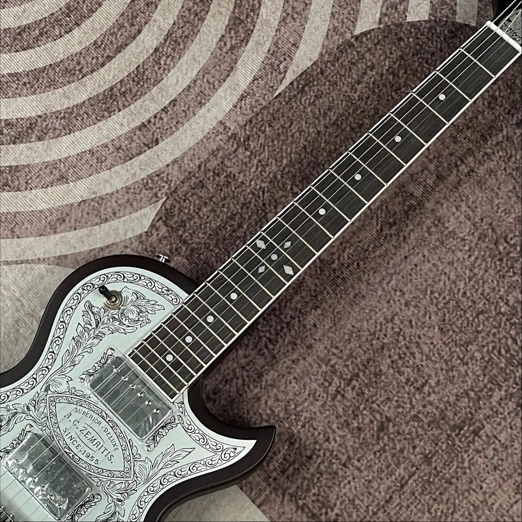 Guitarra eléctrica con tapa de aluminio grabado, cuerpo de caoba, incrustaciones de ébano en la tapa, doble sistema de pastillas humbucker, puente fijo cromado, 22 trastes.