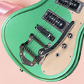 Guitarra eléctrica de 6 cuerdas, de color verde metálico, con herrajes plateados y placa protectora de color beige. Ideal para principiantes.