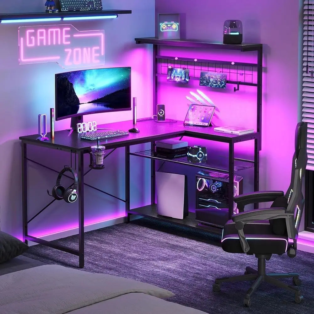 Escritorio gaming negro con estructura metálica y estantes; iluminación LED y bandeja superior