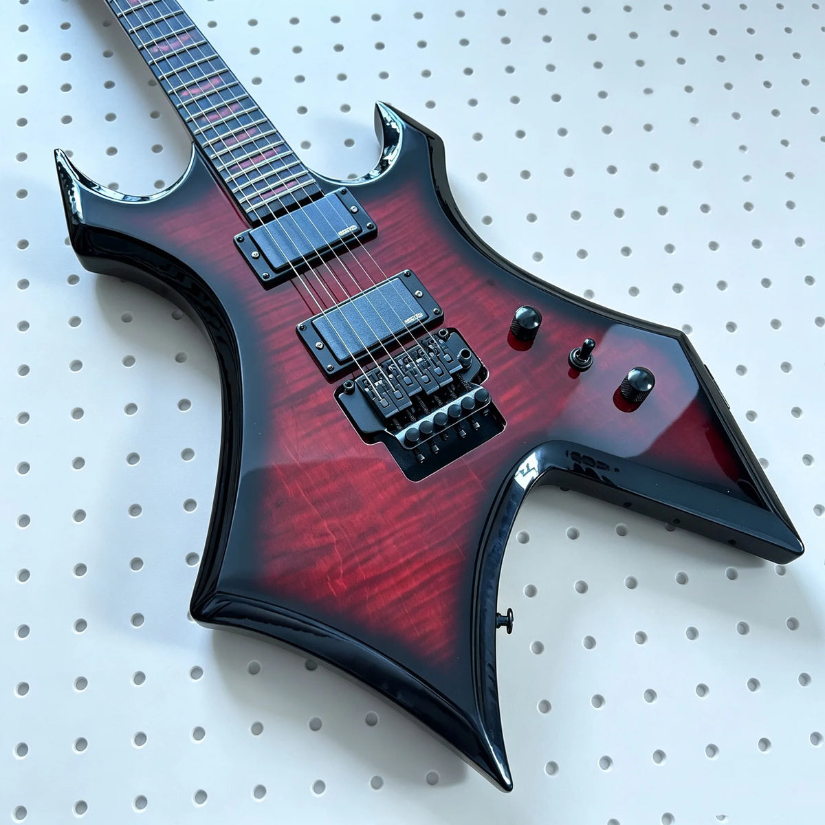Guitarra eléctrica de cuerpo sólido, diseño personalizado, acabado en rojo y negro con detalles en color burdeos, tapa de arce con diseño acolchado, doble pastilla humbucker, sistema de bloqueo doble, trémolo metálico.