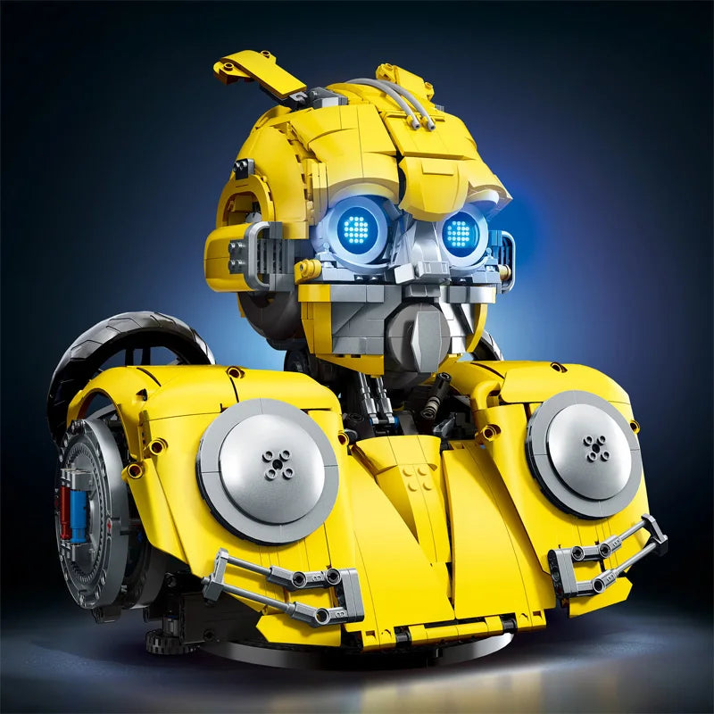 Robot mecánico amarillo con ojos LED azules, dos ruedas traseras y panel gris