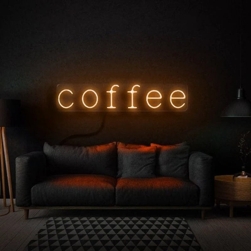 Letrero LED de neón con texto “coffee” en luz blanco cálido sobre pared.