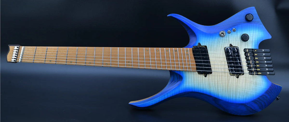 Guitarra eléctrica sin clavijero, con 7 cuerdas, trastes en forma de abanico, cuello con unión en forma de cuña, color azul brillante y cuello de madera de wengué.