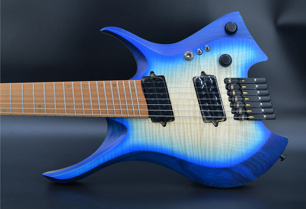 Guitarra eléctrica sin clavijero, con 7 cuerdas, trastes en forma de abanico, cuello con unión en forma de cuña, color azul brillante y cuello de madera de wengué.