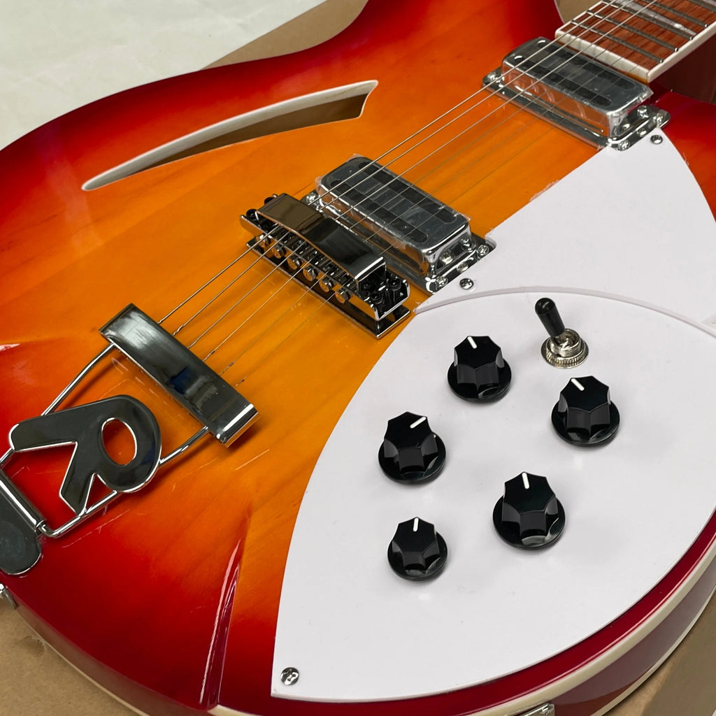 Guitarra eléctrica de 6 cuerdas, cuerpo semi-hueco con degradado de atardecer, pickguard blanco, perillas de volumen negras, guitarra para presentaciones en escenario.