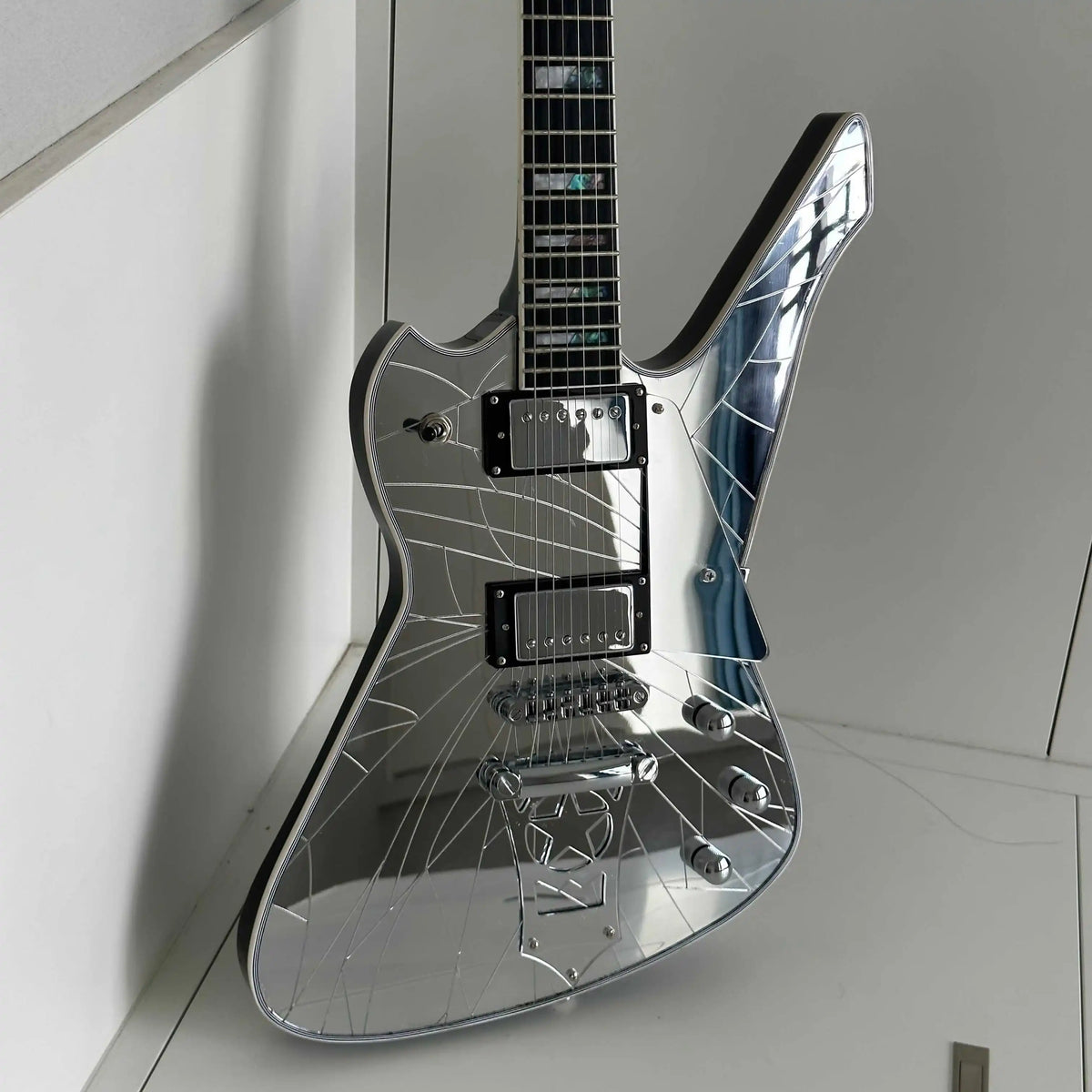 Guitarra eléctrica asimétrica, incrustaciones de perlas de abulón en forma de bloque dividido, cuerpo y tapa trasera con acabado espejado, protector de cuerdas con forma de estrella, pastillas HH.