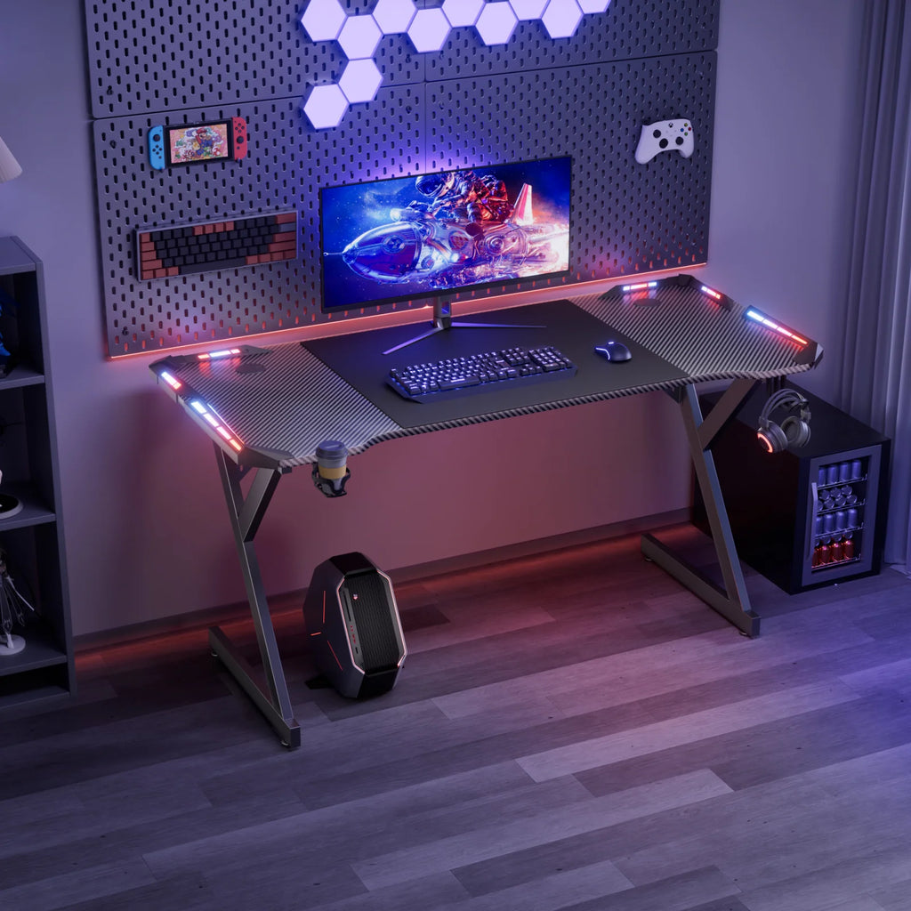 Escritorio gamer en Y con luces RGB, teclado y monitor sobre superficie texturizada