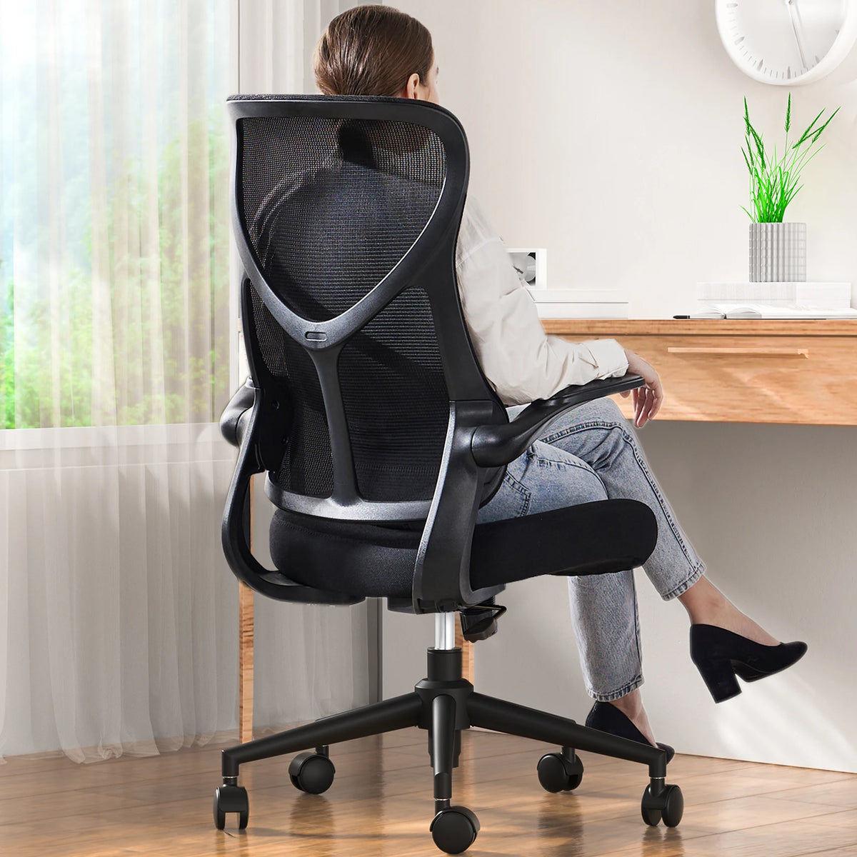 Silla de oficina con respaldo alto de malla negra, reposabrazos curvos y base con ruedas