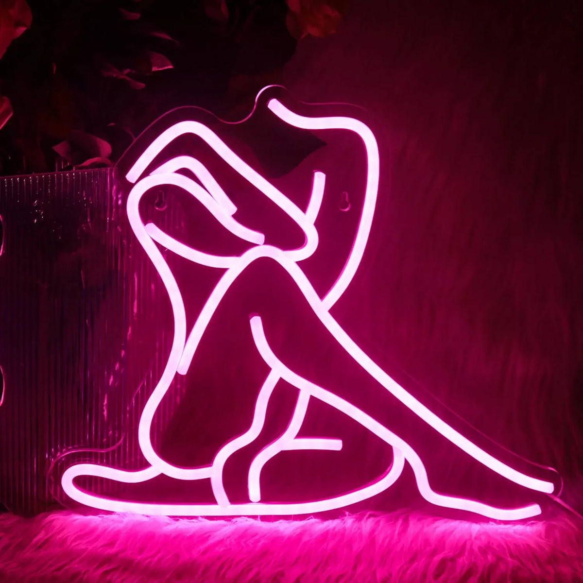 Letrero de neón LED rosa con silueta femenina tumbada en pose curvada