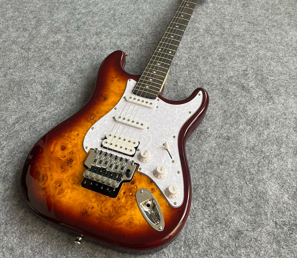 Guitarra de alta calidad con acabado Sunburst, incrustaciones de estrellas, sistema de trémolo y pastillas SSH 2026