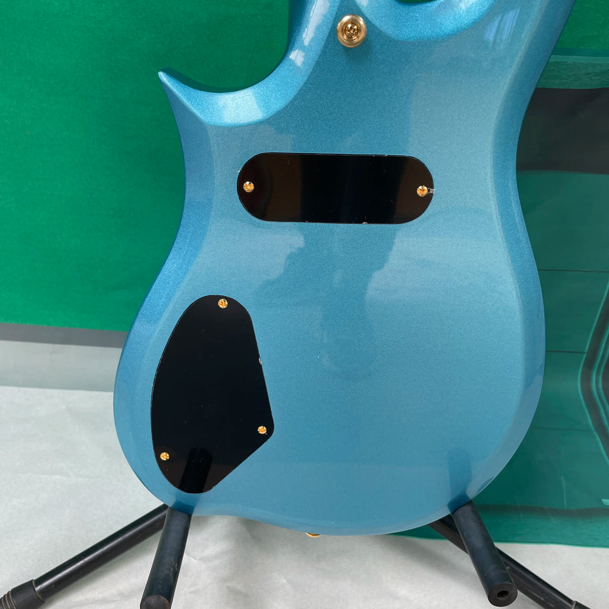 Guitarra eléctrica de 6 cuerdas, un cuerpo único en forma de nube asimétrica y herrajes dorados, una guitarra inusual y distintiva.