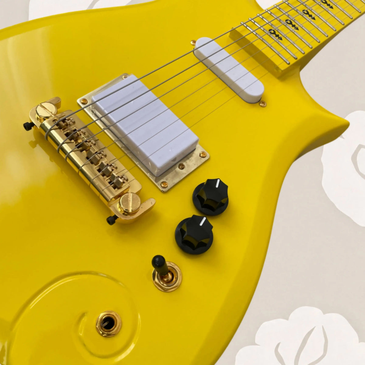 Guitarra eléctrica de color amarillo brillante con acabado de alto brillo, herrajes dorados, incrustaciones con motivos artísticos para presentaciones en vivo.