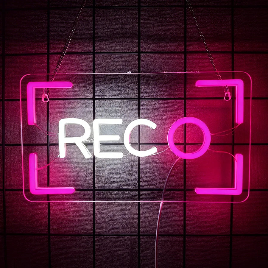 Letrero LED neón tipo cámara REC con marco rosa y letras blancas, estilo grabación