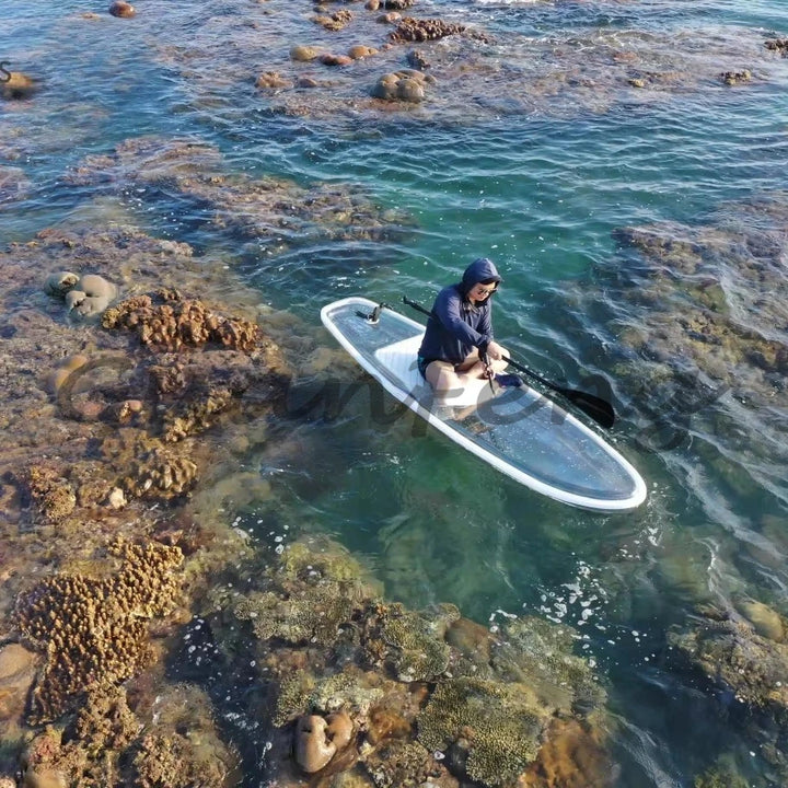 Tabla de paddle surf transparente con base transparente de material PC cristalino para deportes acuáticos.