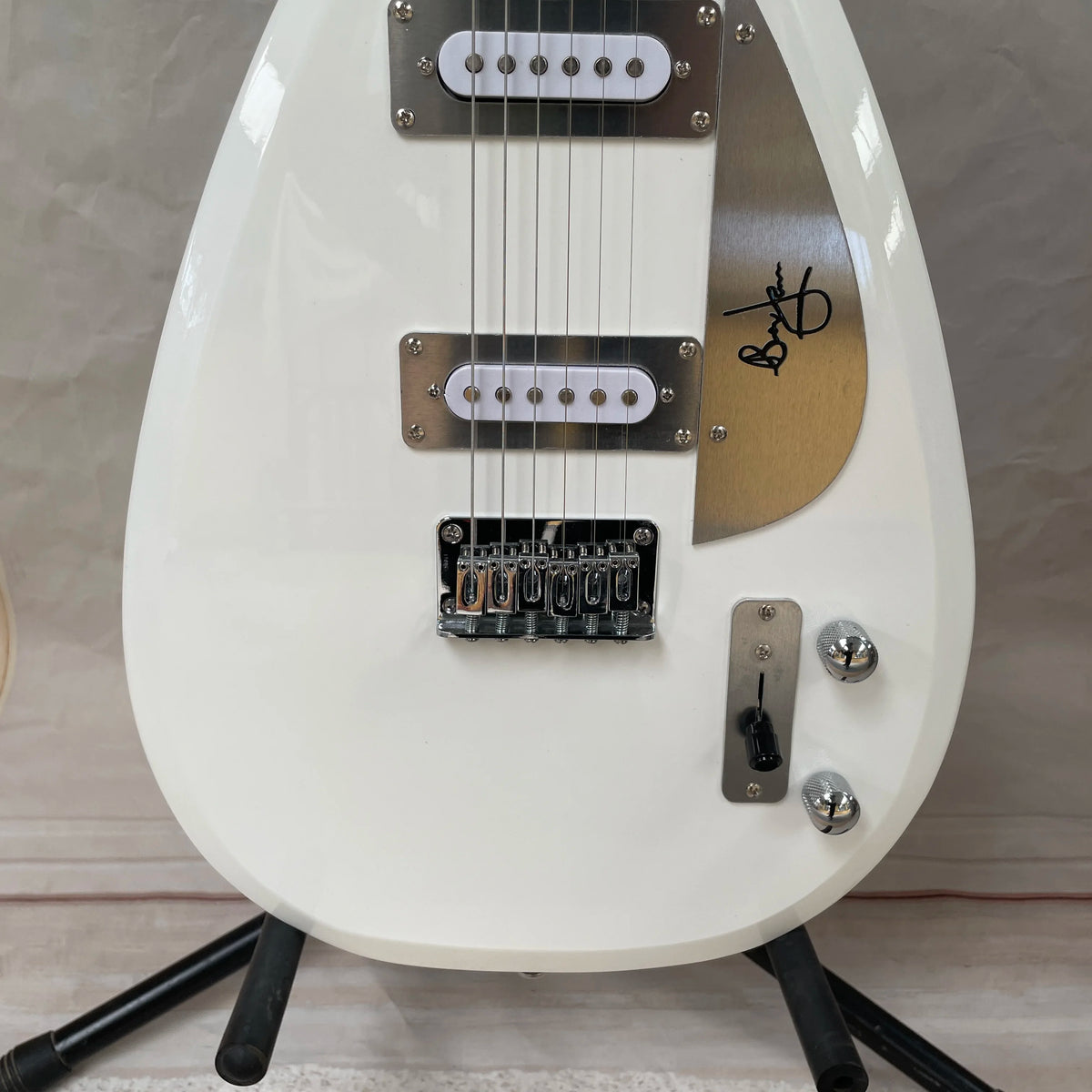 Guitarra eléctrica minimalista de color blanco con forma de lágrima, con pastillas SS y diapasón de palisandro, una guitarra elegante y distintiva.